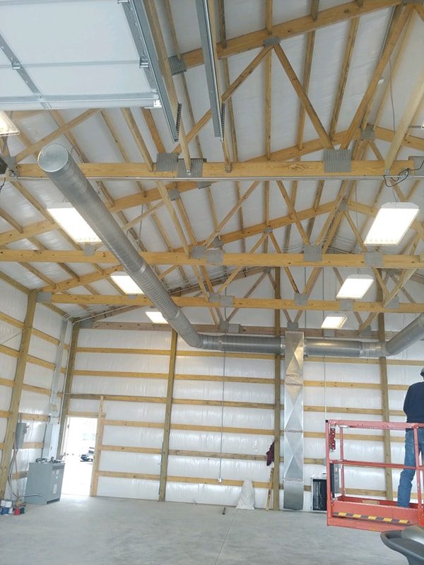 Ductwork hung in a commercial building, with a lift on site