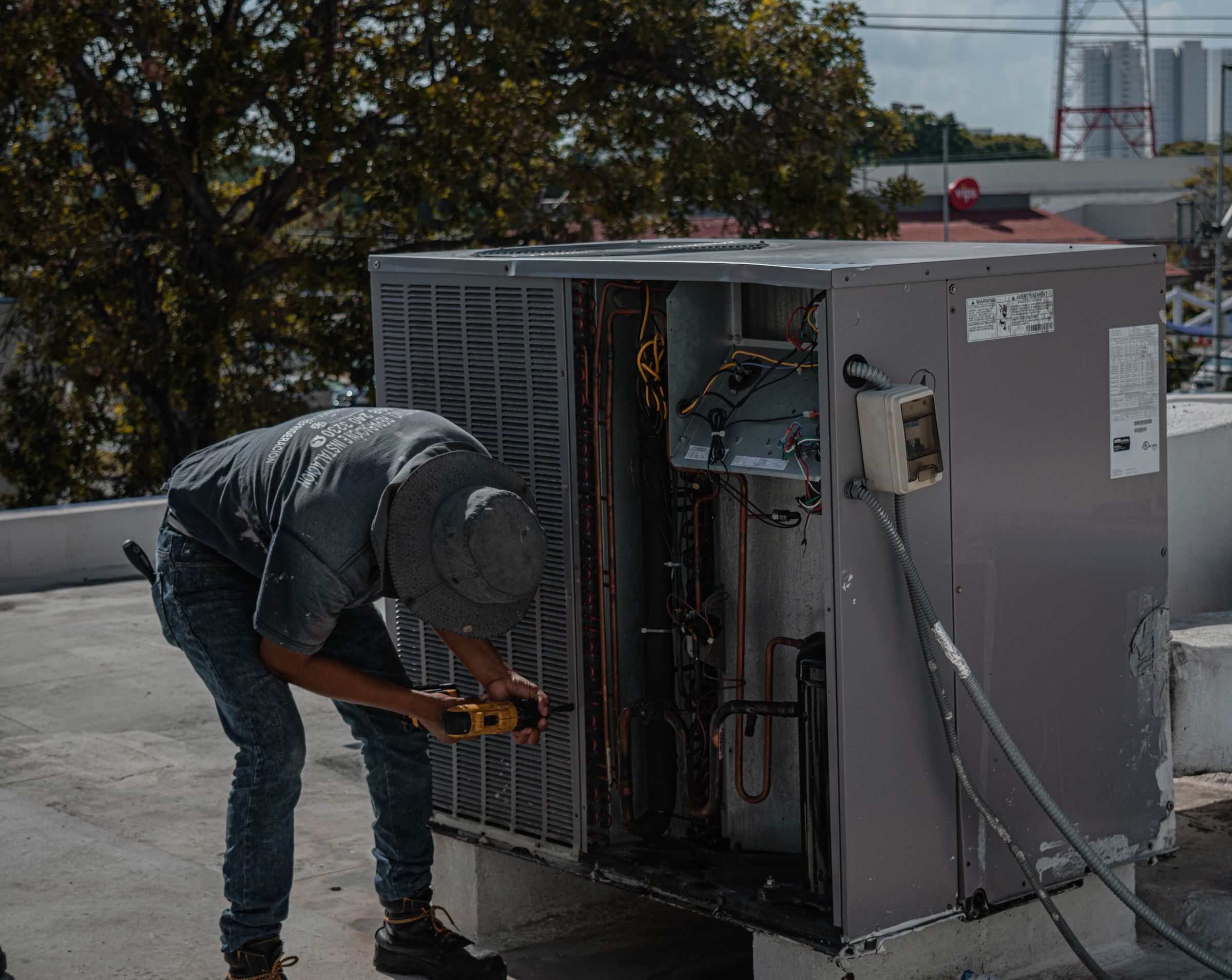Technician working on a rooftop HVAC unit